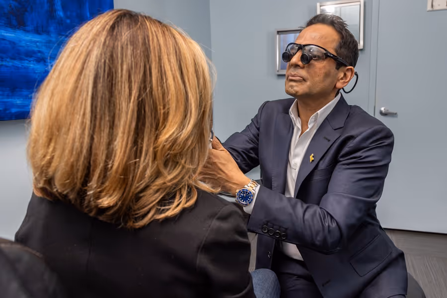 Doctor examining patient’s face with glasses on